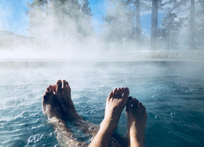 Steam rising off a hot tub in a wooded setting