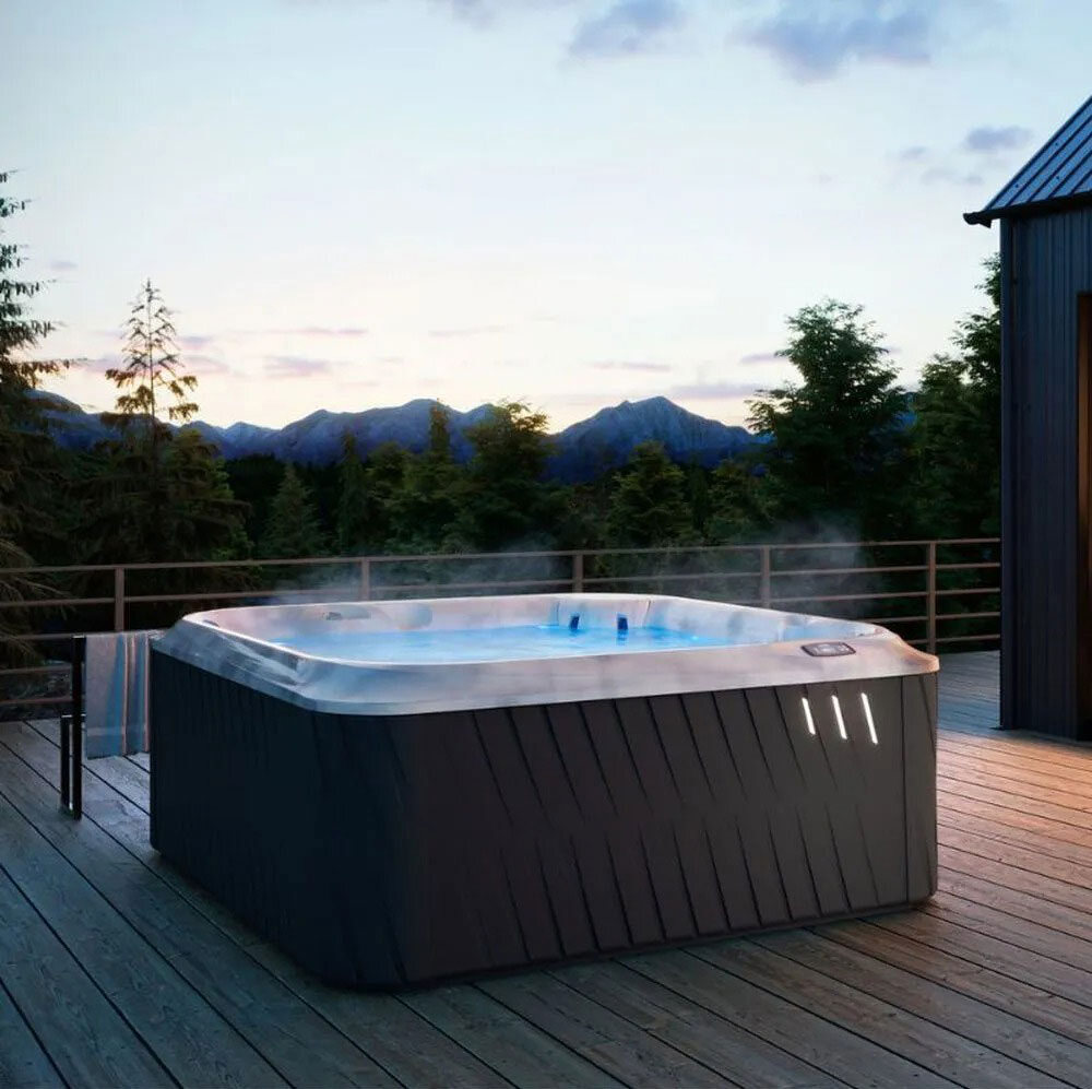 A Jacuzzi hot tub on a wood deck at sunset