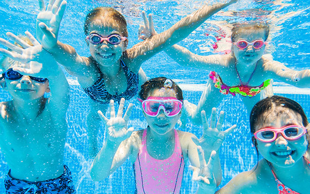 Children swimming in a backyard above-ground pool